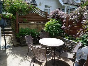 Bassenthwaite LakeMeadowside Cottage的庭院配有桌椅和鲜花