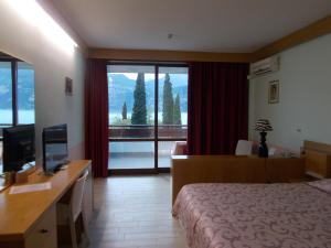 马尔切西内劳拉克里斯蒂娜酒店的酒店客房配有一张床和一张书桌及一台电视