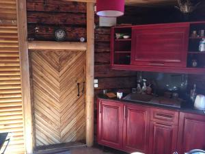ReikiBondari - countryside experience near Rēzekne的一间设有红色橱柜和木门的厨房