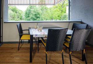 巴特奥塞Ferienwohnung Narzisse - City Appartement im Kurpark Bad Aussee的餐桌、四把椅子和窗户