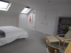 伦敦Sandra & Andrew's B&B的一间卧室配有床、沙发和书架