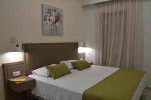 法拉萨纳Romantica Apartments的卧室配有带绿色枕头的大型白色床
