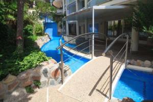 萨洛Cap Salou Zeus的一座蓝色海水游泳池,位于大楼旁