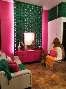 AquismónHotel Boutique Santa Lucía的一间配有沙发、镜子和粉红色墙壁的客房