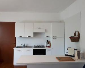 里奥内莱尔巴Nisportino的厨房配有白色橱柜和炉灶烤箱。