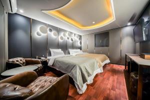 首尔THE GRAY HOTEL的一间卧室配有一张床、一张沙发和椅子