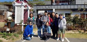 庆州庆州提阿莫度假屋的一群人站在一座建筑物前摆着一张照片
