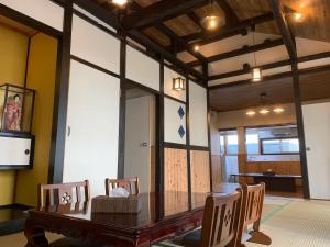 冲绳岛市Condominium WAFU TEI Okinawa city的一间带木桌和椅子的用餐室