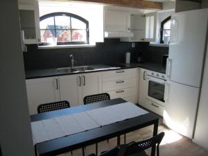 Fegenstixered fegen的厨房配有白色橱柜和桌椅