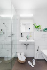 苏黎世Swiss Star Oerlikon Lodge - Self Check-In的白色的浴室设有水槽和淋浴。