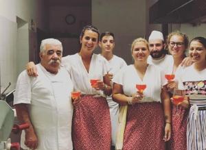 普雷圣迪迪埃Hotel Beau Sejour Pré-Saint-Didier的一群人站在一个厨房里,拿着酒杯