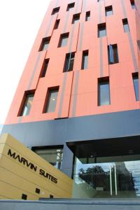 曼谷Marvin Suites Hotel的前面有标志的红色建筑