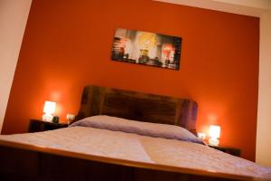 恩波利拉特拉扎住宿加早餐旅馆的一间卧室配有橙色墙壁、一张床和两盏灯