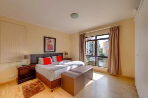 开普敦Majorca Self-Catering Apartments的一间卧室设有一张大床和一个窗户。