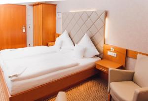 泰克伦堡图托贝格沃尔德环形酒店的酒店客房带一张大床和一把椅子