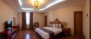 第比利斯第比利斯华凌酒店的酒店客房,配有一张床和吊灯