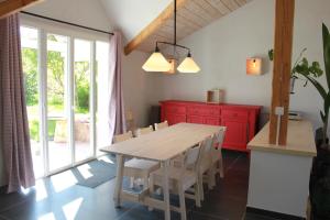 Raon-sur-PlaineGîte le Cerf Volant的厨房配有木桌和红色橱柜。