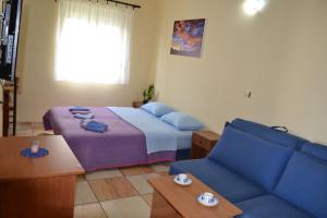 巴尔Apartments Milosevic的一间卧室配有一张床和一张蓝色的沙发