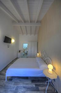 菲纳莱利古雷La Locanda di Cucco的一间带大床和电视的卧室