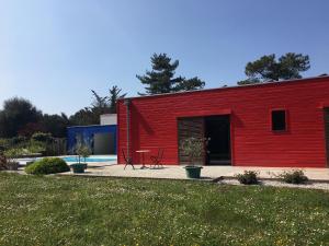 多吕多勒龙Les Naiades的一座红色的建筑,前面有一个游泳池
