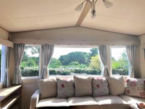 纽基Luxury Holiday Caravan Home的带沙发和大窗户的客厅