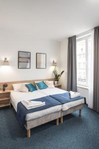 格但斯克Fama Residence Gdańsk Old Town的一间卧室配有一张带蓝色枕头的大床