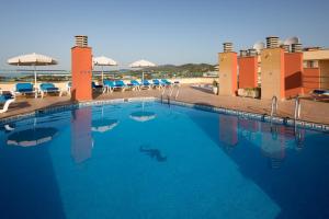 圣苏珊娜htop Royal Sun Suites #htopFun的一个带蓝色椅子和遮阳伞的大型游泳池