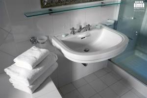 威尼斯Ca' Cerchieri Mezzanine的白色的浴室设有水槽和毛巾。