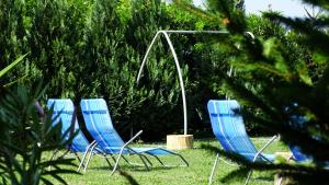 鲍洛通塞迈什骑手海滩酒店的坐在草地上的三把蓝色草坪椅