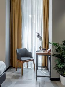 米兰APARTHOTEL CASA MIA的一间卧室配有椅子、桌子和窗户