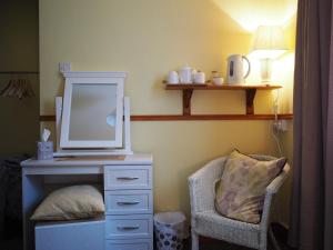 纳斯Inglewood Lodge B&B的一间卧室配有带镜子和椅子的梳妆台