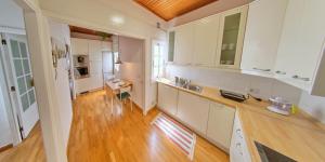 圣克鲁斯-德特内里费NEBRIJA的厨房铺有木地板,配有白色橱柜。