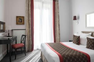 巴黎阿斯托利亚布拉德福德酒店的配有一张床、一张书桌和一扇窗户的酒店客房