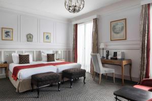 巴黎阿斯托利亚布拉德福德酒店的酒店客房设有一张大床和一张书桌。