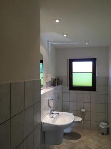 赫费尔霍夫Landhaus Hotel Göke的白色的浴室设有水槽和窗户。