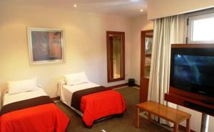 凡塔纳镇El Mirador Complejo Turístico的酒店客房设有两张床和一台平面电视。