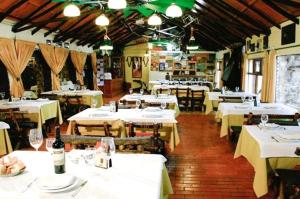 凡塔纳镇El Mirador Complejo Turístico的餐厅配有白色桌椅和葡萄酒瓶
