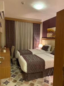 麦加Altelal Apartment的配有一张床和一张书桌的酒店客房