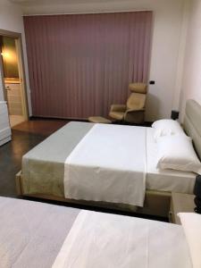 圣塞韦罗B&B RISTOBAR CRISTAL By Varenne的酒店客房带一张大床和一把椅子