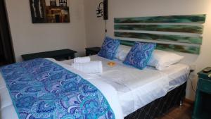 德尔迪阿布罗角El Bodegón Hostal Boutique的一张带蓝色和白色床单及枕头的床