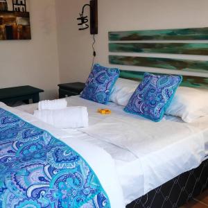 德尔迪阿布罗角El Bodegón Hostal Boutique的一张带蓝色和白色床单及枕头的床