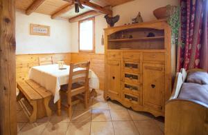 贝桑Chalet la Lauzette的一间带桌子和木柜的用餐室