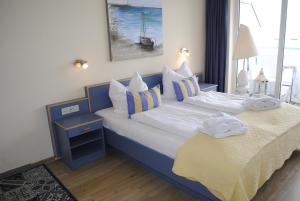 奥斯赛拜-屈隆斯博恩Ferienwohnung Yachthafenperle的一间卧室配有两张蓝色和白色的床