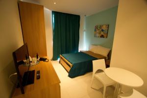 马尔萨什洛克海港旅舍的小房间设有一张床、一张桌子和一张书桌