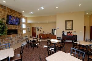 Fort MadisonCobblestone Inn & Suites Fort Madison的一间带桌椅和壁炉的用餐室