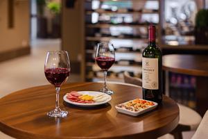 格拉玛多Hotel Fioreze Primo的一张木桌,上面放着两杯葡萄酒和食物