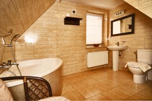 希维拉杜夫-兹德鲁伊Willa Ostoja的带浴缸、卫生间和盥洗盆的浴室