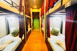 孟买Town Hostel Mumbai - AC Dormitory的走廊上设有三张双层床。