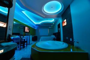 布卢梅瑙Amy Motel的蓝色灯的客房内设有带大浴缸的浴室
