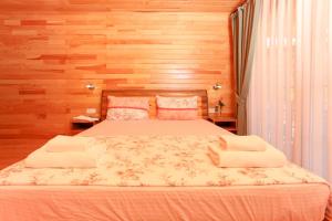 契拉勒Dolunay Apart Hotel的一间卧室配有一张带木墙的大床